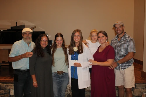 A member of the junior nursing class and her family smiling.